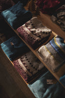 Stack of folded sweaters on a wooden surface